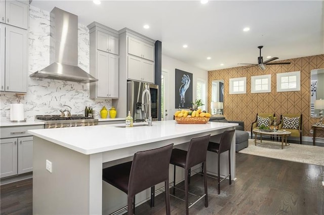 1821 Huntington Hills Ln NW, Atlanta, GA 30309 - kitchen with wall chimney exhaust hood, an accent wall, gray cabinets, open floor plan, and recessed lighting
