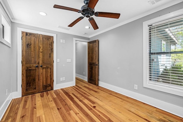 unfurnished bedroom featuring baseboards, light wood finished floors, recessed lighting, a ceiling fan, and crown molding