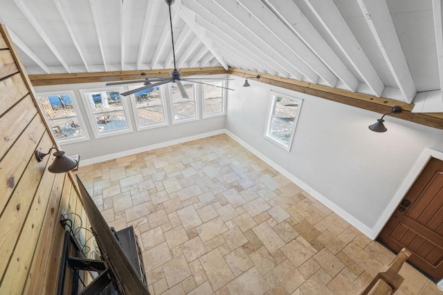 bonus room with stone tile flooring, baseboards, and a ceiling fan