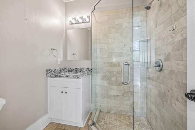 full bath featuring a shower stall, vanity, and baseboards
