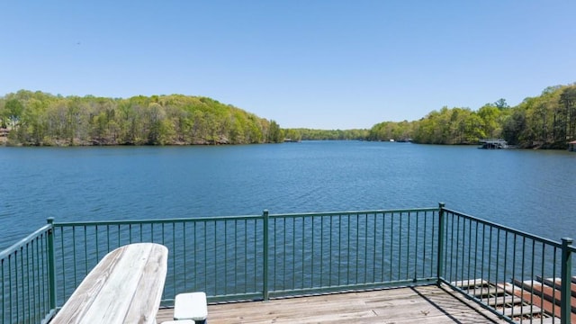 balcony featuring a water view and a wooded view