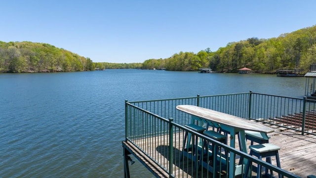 dock area featuring a water view and a wooded view