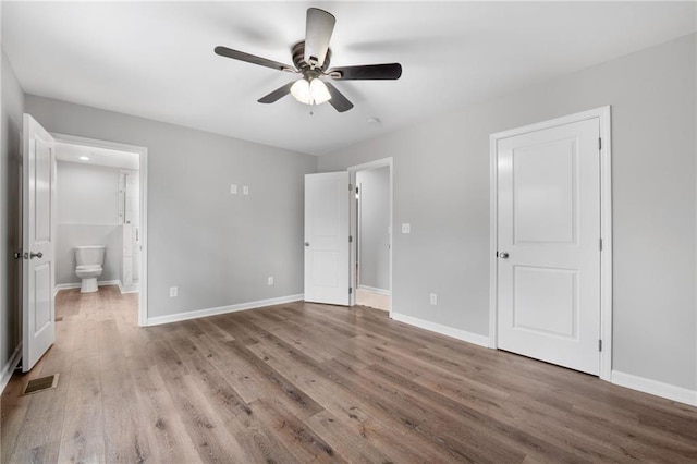 unfurnished bedroom featuring ceiling fan, ensuite bath, and light wood-type flooring