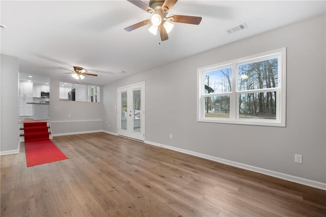 unfurnished living room with light hardwood / wood-style floors, french doors, and ceiling fan