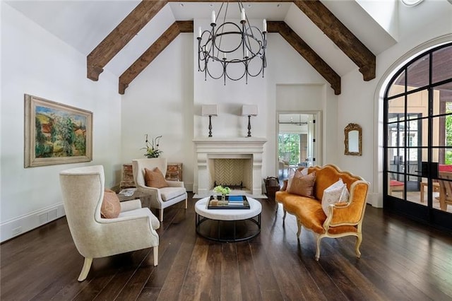 living area featuring beam ceiling, high vaulted ceiling, dark wood-type flooring, and an inviting chandelier