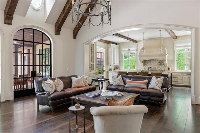 living room featuring beamed ceiling, dark hardwood / wood-style flooring, plenty of natural light, and an inviting chandelier