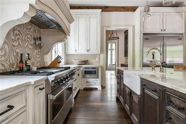 kitchen featuring pendant lighting, premium range hood, dark hardwood / wood-style flooring, premium appliances, and white cabinetry