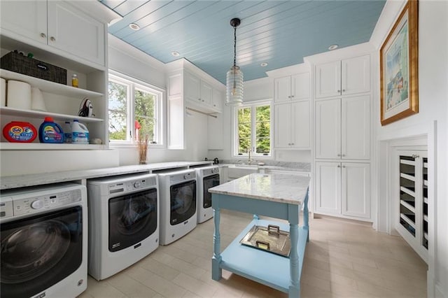 washroom featuring cabinets, sink, plenty of natural light, and washer and clothes dryer