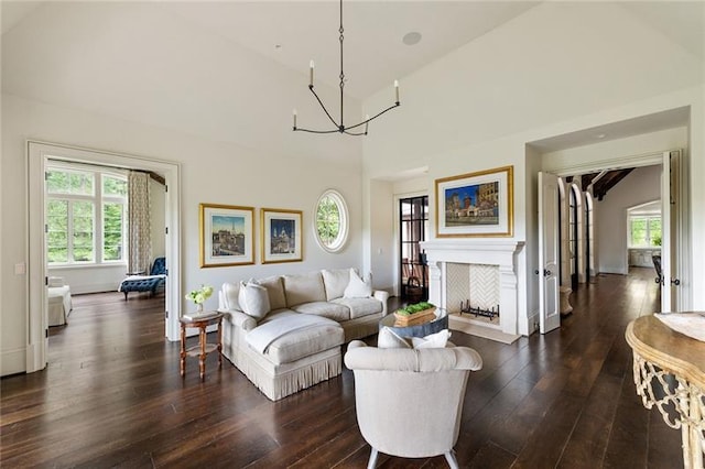 living room featuring high vaulted ceiling, dark hardwood / wood-style floors, and an inviting chandelier