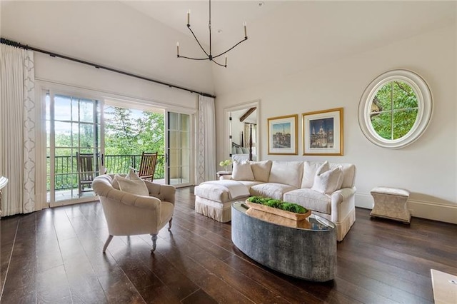 living room with a healthy amount of sunlight, dark hardwood / wood-style floors, a high ceiling, and a notable chandelier