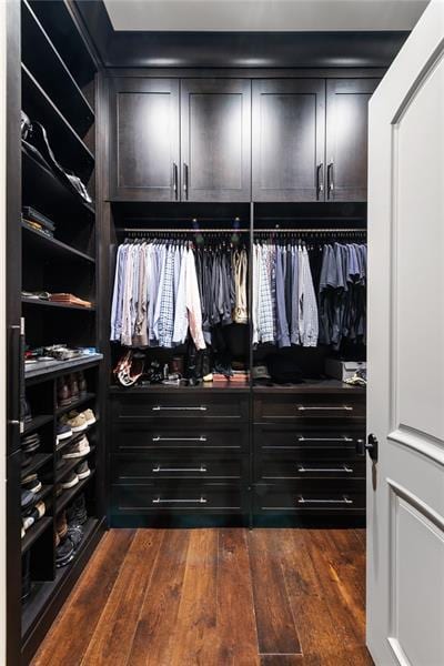 walk in closet with dark wood-type flooring