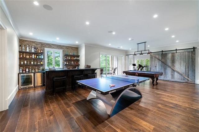 playroom featuring a barn door, dark wood-type flooring, billiards, and indoor bar