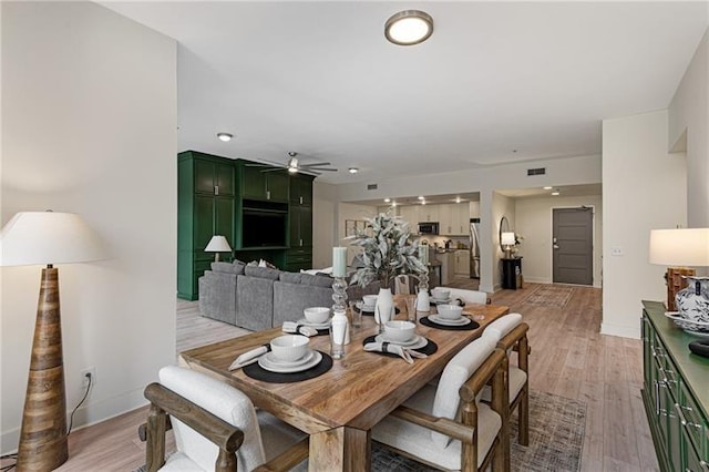 dining space with ceiling fan and light hardwood / wood-style floors