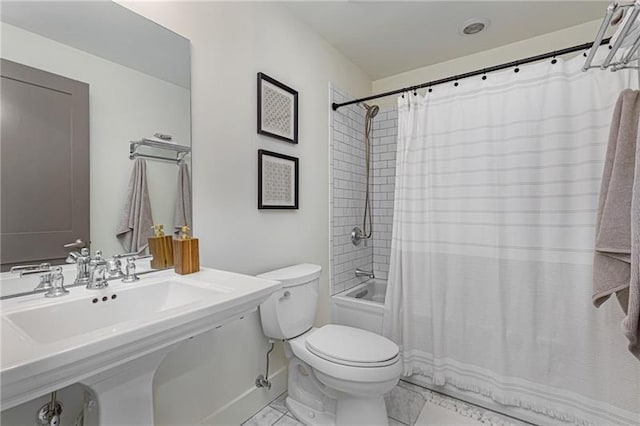 full bathroom featuring sink, shower / tub combo with curtain, and toilet