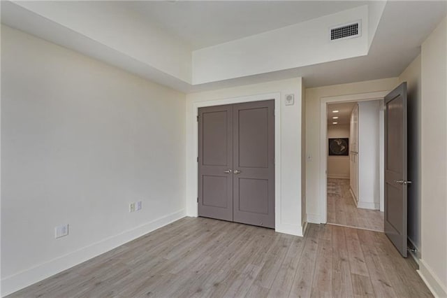 unfurnished bedroom featuring light hardwood / wood-style flooring and a closet