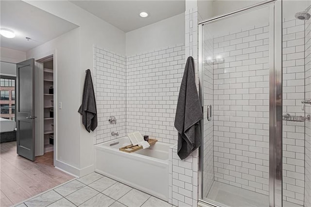 bathroom with shower with separate bathtub and tile patterned flooring