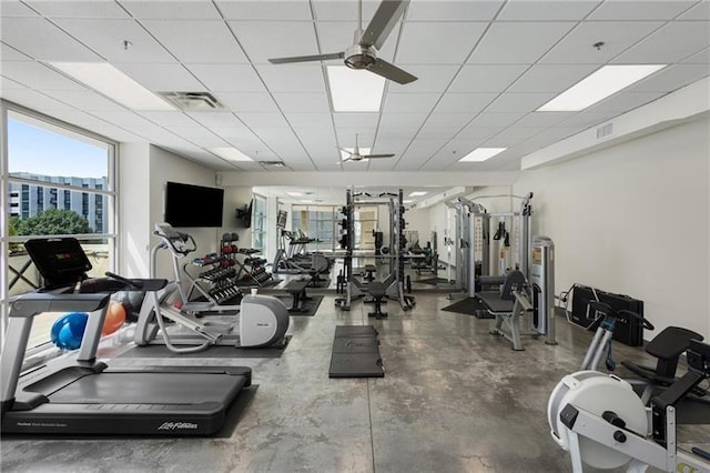 exercise room with a paneled ceiling and ceiling fan