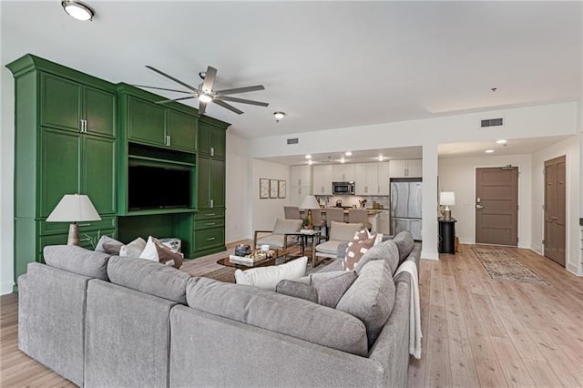 living room with ceiling fan and light wood-type flooring