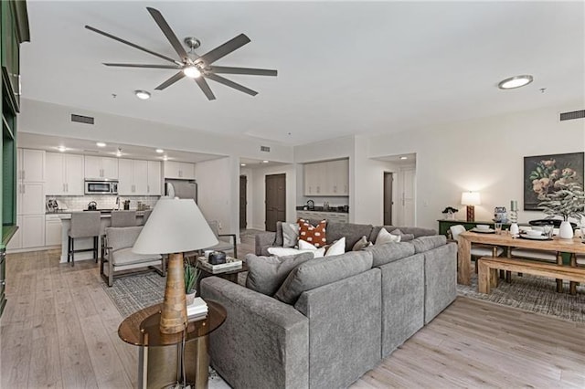 living room featuring ceiling fan and light hardwood / wood-style floors