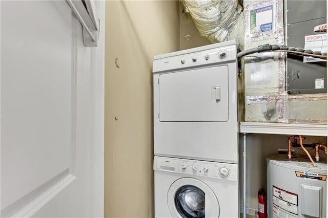 laundry area with electric water heater and stacked washer and dryer