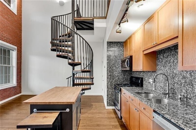 kitchen with butcher block countertops, a center island, brick wall, and appliances with stainless steel finishes