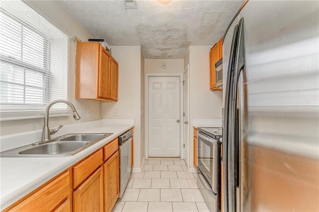 3623 Thurleston Ct SW, Marietta, GA 30008 - kitchen with stainless steel appliances, light tile patterned floors, light countertops, brown cabinets, and a textured ceiling