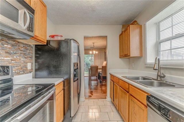 3623 Thurleston Ct SW, Marietta, GA 30008 - kitchen featuring appliances with stainless steel finishes, light countertops, a chandelier, a textured ceiling, and tasteful backsplash