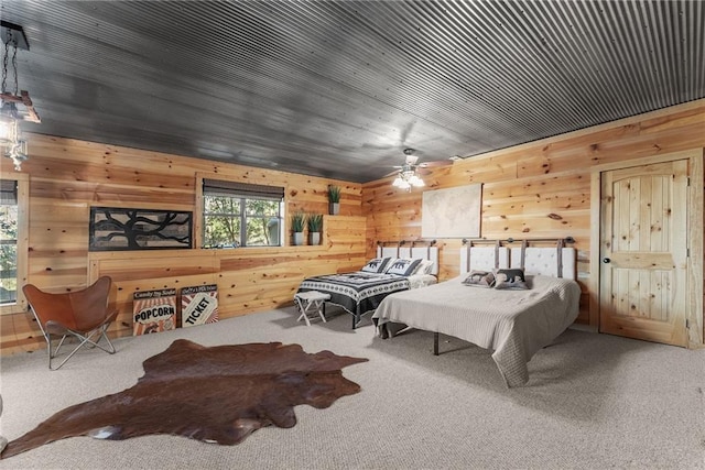 bedroom with wooden walls, ceiling fan, and carpet