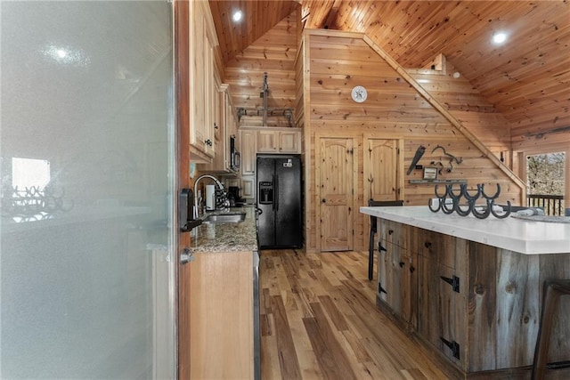 kitchen featuring wooden ceiling, vaulted ceiling, black refrigerator with ice dispenser, a sink, and light wood-type flooring