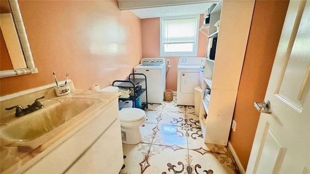 bathroom with tile flooring, large vanity, toilet, and washing machine and clothes dryer