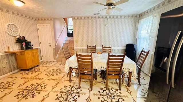 dining area with ceiling fan, a textured ceiling, and light tile floors