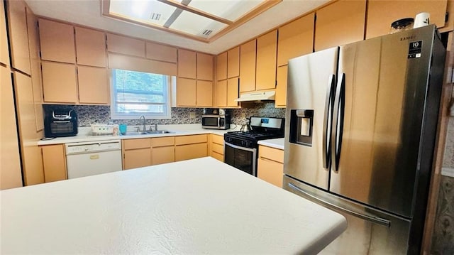 kitchen with light brown cabinets, sink, backsplash, and appliances with stainless steel finishes