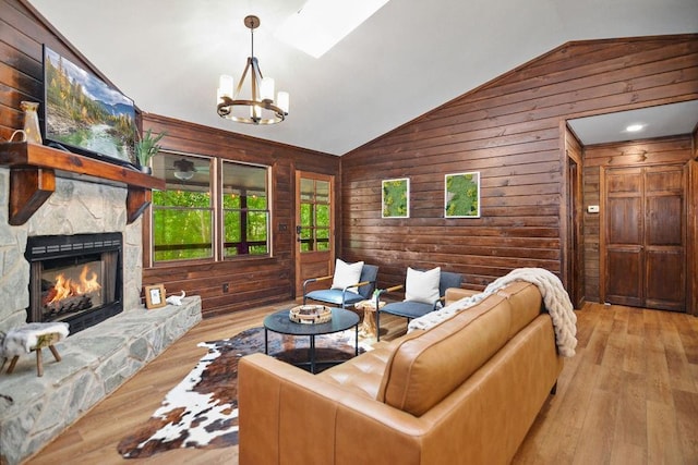 307 Pigeon Creek Rd, Blue Ridge, GA 30513 - living area with lofted ceiling, wooden walls, wood-type flooring, a chandelier, and a stone fireplace