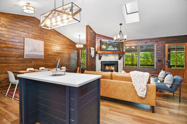 307 Pigeon Creek Rd, Blue Ridge, GA 30513 - living room featuring wood walls, a skylight, light wood-style floors, a stone fireplace, and a chandelier