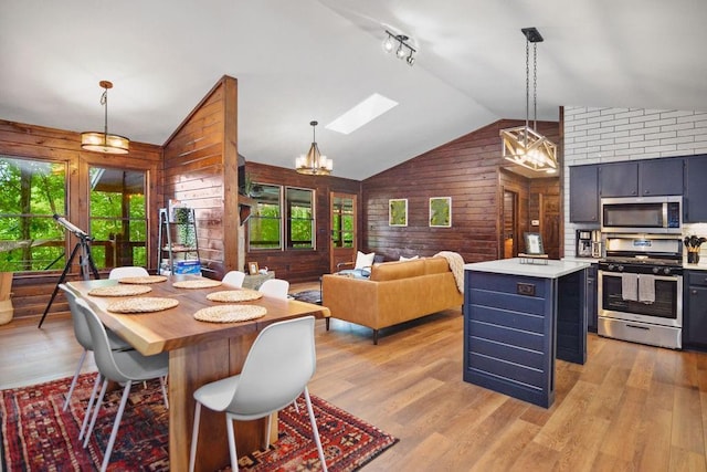 307 Pigeon Creek Rd, Blue Ridge, GA 30513 - dining room with wood walls, lofted ceiling, a skylight, light wood-type flooring, and a chandelier