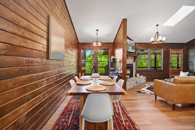 307 Pigeon Creek Rd, Blue Ridge, GA 30513 - dining room with wooden walls, healthy amount of natural light, wood finished floors, a stone fireplace, and a skylight