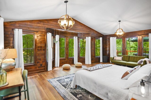 307 Pigeon Creek Rd, Blue Ridge, GA 30513 - bedroom with wood walls, lofted ceiling, multiple windows, wood finished floors, and a chandelier