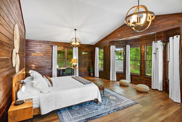 307 Pigeon Creek Rd, Blue Ridge, GA 30513 - bedroom featuring a chandelier, wooden walls, vaulted ceiling, and wood finished floors