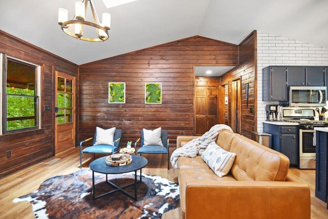 307 Pigeon Creek Rd, Blue Ridge, GA 30513 - living area with lofted ceiling, a chandelier, wooden walls, and light wood-style floors