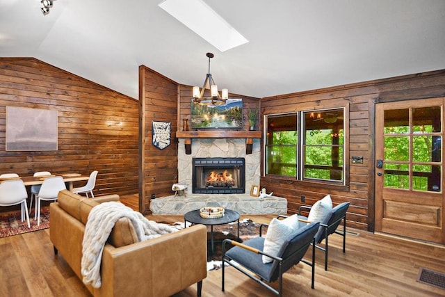 307 Pigeon Creek Rd, Blue Ridge, GA 30513 - living room with wooden walls, lofted ceiling, a skylight, wood finished floors, and a stone fireplace