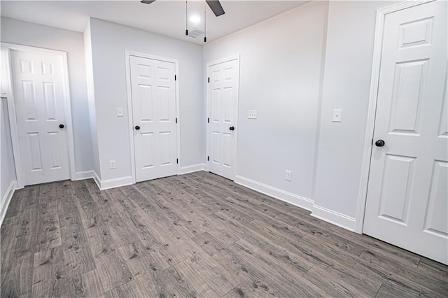 unfurnished bedroom featuring ceiling fan and dark hardwood / wood-style flooring