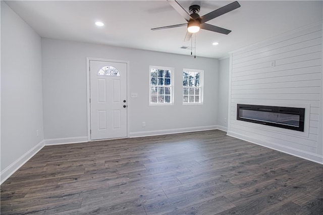 foyer featuring ceiling fan, a large fireplace, and dark hardwood / wood-style flooring