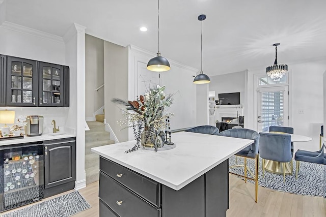 kitchen featuring pendant lighting, light hardwood / wood-style floors, wine cooler, and a kitchen island