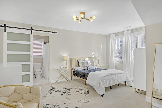 bedroom featuring carpet flooring, connected bathroom, a chandelier, and a barn door