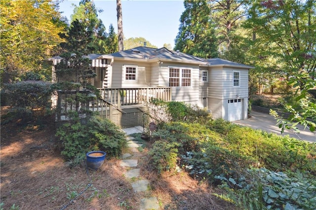 view of front of home with driveway, an attached garage, and stairs