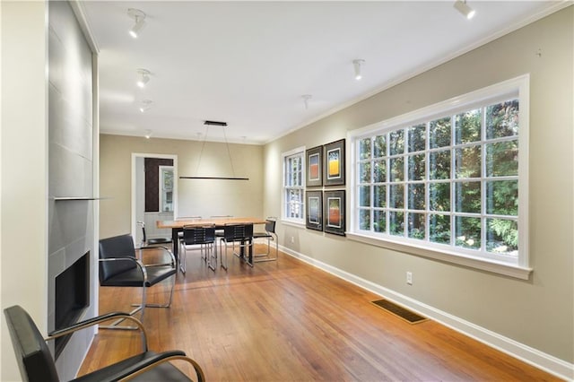 home office with ornamental molding, visible vents, baseboards, and wood finished floors