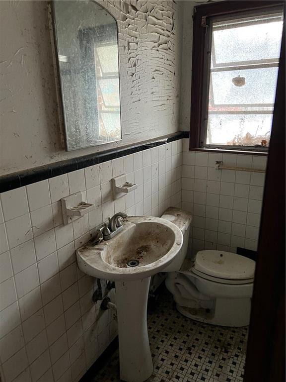 bathroom featuring tile patterned floors, tile walls, and toilet