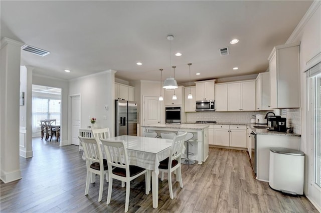 dining room featuring crown molding, sink, and light hardwood / wood-style flooring