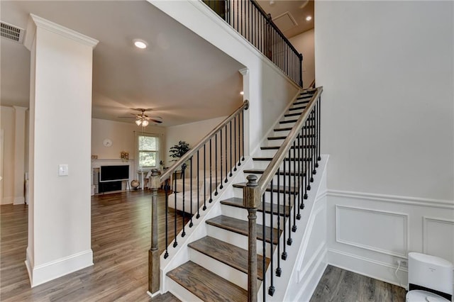 stairs with ceiling fan and hardwood / wood-style flooring