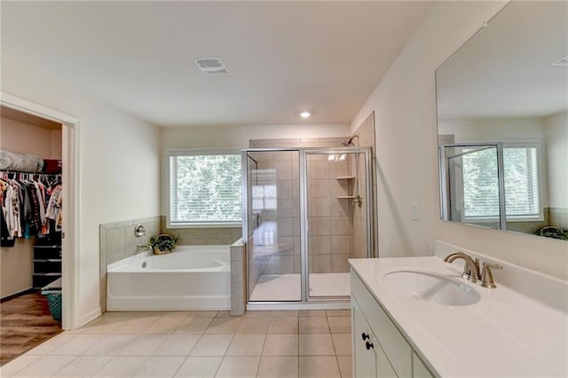 bathroom with tile patterned flooring, vanity, and separate shower and tub